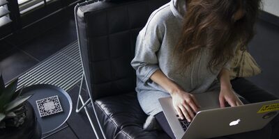 Lady working remotely on laptop in casual clothing.